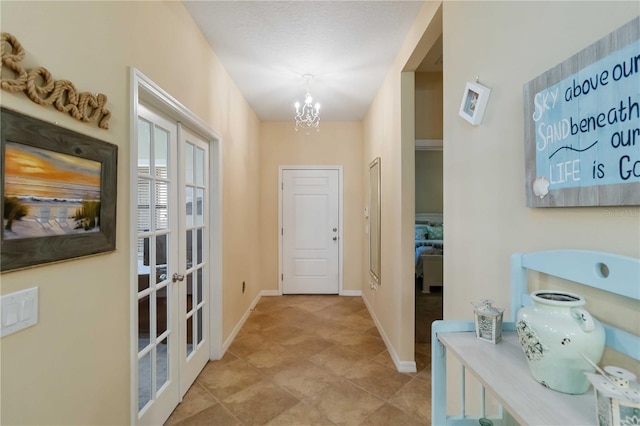 entryway featuring baseboards, french doors, and a notable chandelier