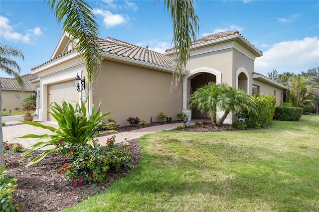 mediterranean / spanish-style home featuring a front yard, an attached garage, a tile roof, and stucco siding