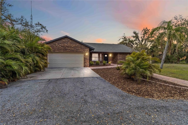 view of front of home with a garage, brick siding, and driveway