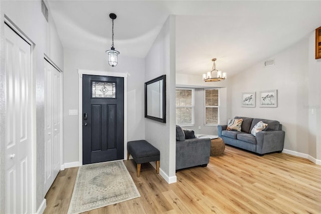 entryway with baseboards, visible vents, and light wood finished floors