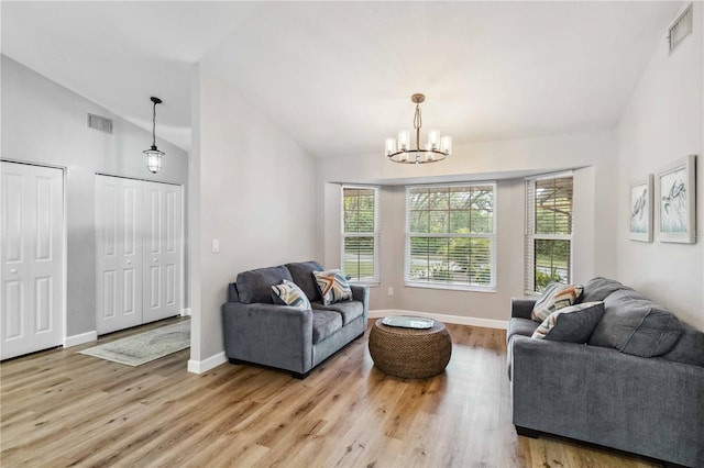 living room with lofted ceiling, light wood-style flooring, and visible vents