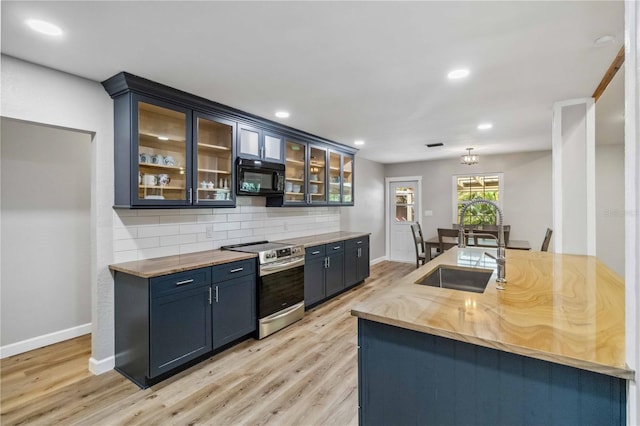 kitchen featuring black microwave, a sink, light wood-style floors, stainless steel range with electric cooktop, and decorative backsplash