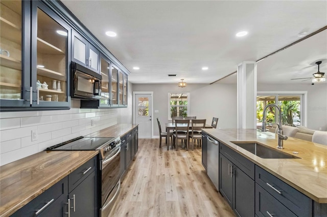 kitchen featuring stainless steel appliances, a healthy amount of sunlight, a sink, and decorative backsplash