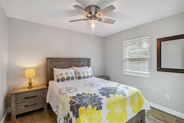 bedroom featuring ceiling fan, wood finished floors, and baseboards