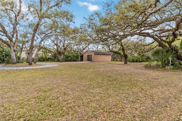 view of yard featuring a garage and an outbuilding