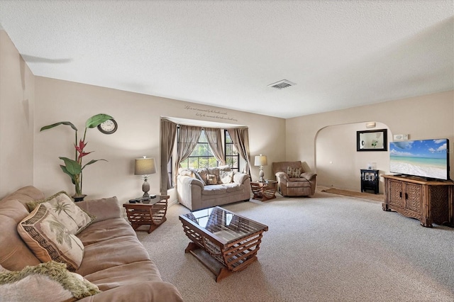 living room featuring carpet, visible vents, and a textured ceiling