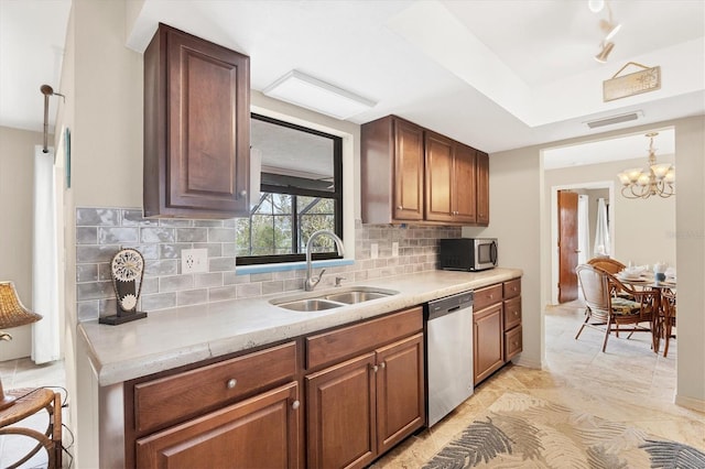 kitchen featuring a chandelier, stainless steel appliances, a sink, visible vents, and backsplash