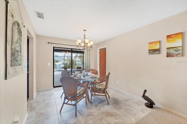 dining area with a chandelier, a textured ceiling, visible vents, and baseboards