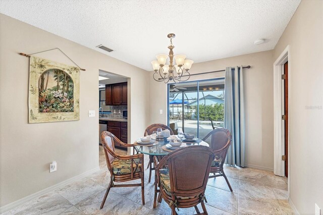 dining room with visible vents, a textured ceiling, baseboards, and an inviting chandelier