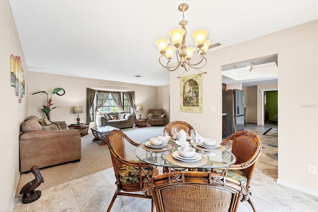 dining room with baseboards, visible vents, and a notable chandelier