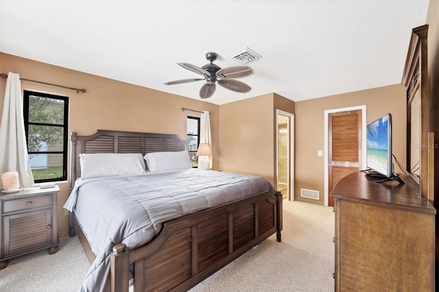 bedroom with baseboards, visible vents, and light colored carpet