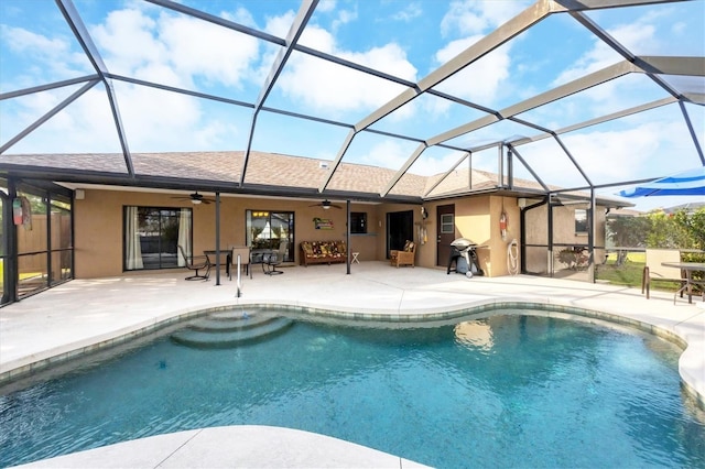 outdoor pool featuring glass enclosure, a patio area, and a ceiling fan