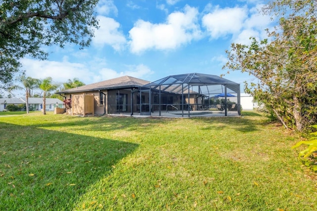 back of property with glass enclosure and a lawn