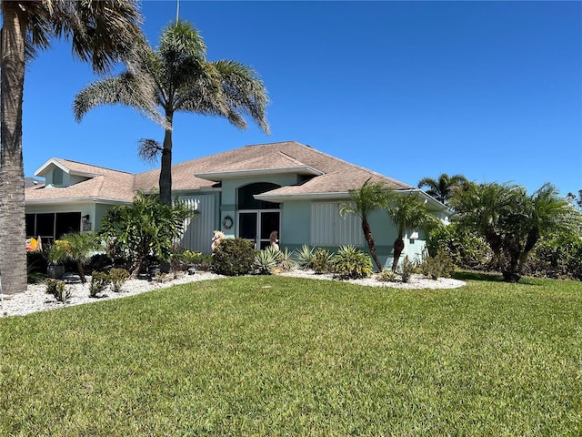 view of front of house featuring a garage, a front yard, and stucco siding