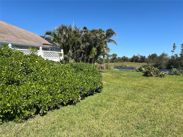 view of yard with a water view and fence