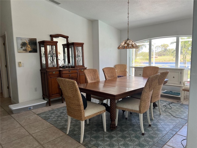 dining area featuring tile patterned floors, a textured ceiling, and visible vents