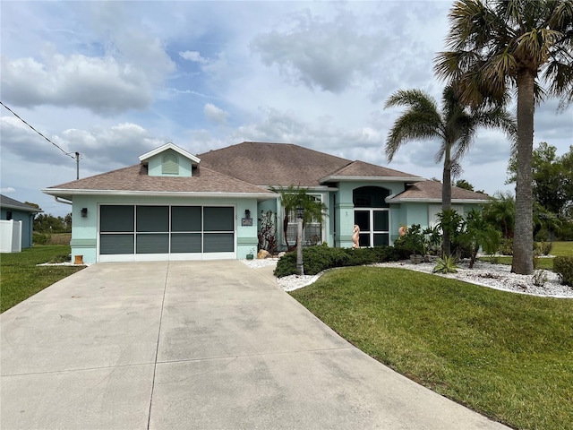 ranch-style home featuring a garage, stucco siding, driveway, and a front yard