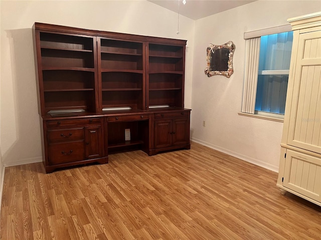 unfurnished office with baseboards and light wood finished floors