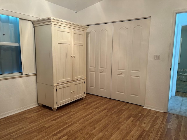 108 Fairway Rd, Rotonda West, FL 33947 - unfurnished bedroom featuring wood finished floors, a closet, and baseboards