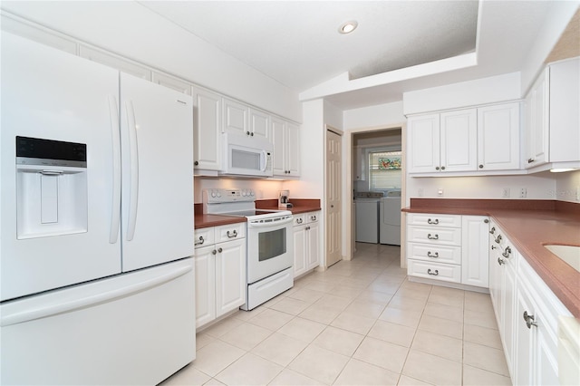 kitchen with white cabinets, white appliances, washer and clothes dryer, and lofted ceiling