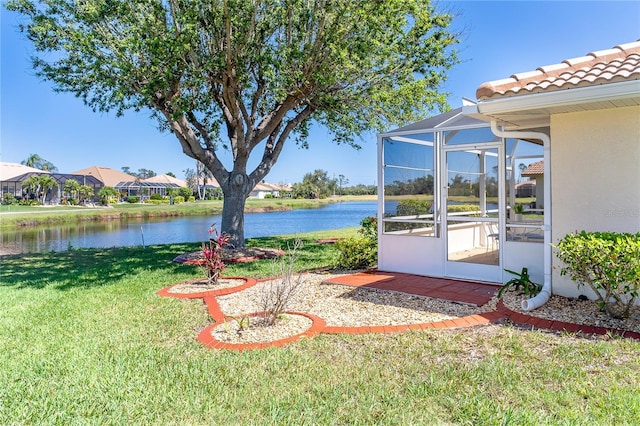 view of yard featuring a water view and glass enclosure