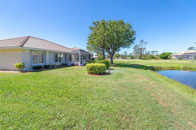 view of yard featuring a lanai and a water view