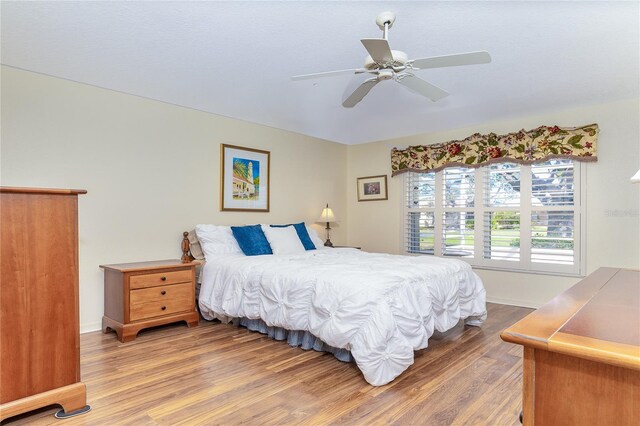 bedroom featuring baseboards, a ceiling fan, and wood finished floors