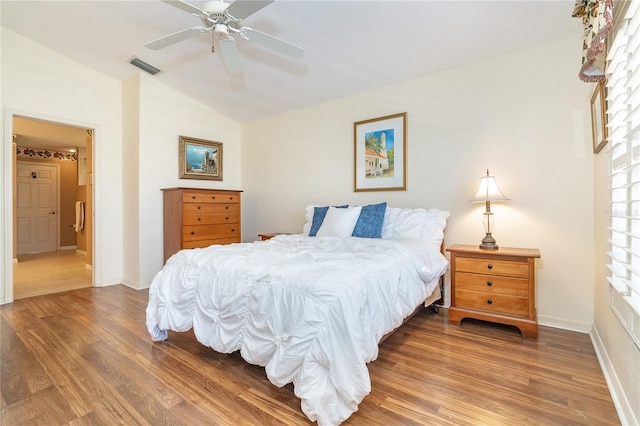 bedroom featuring lofted ceiling, visible vents, a ceiling fan, wood finished floors, and baseboards