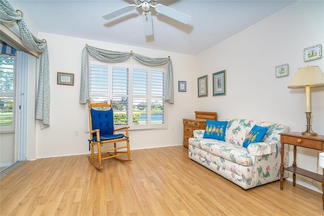 living area with ceiling fan, wood finished floors, and baseboards