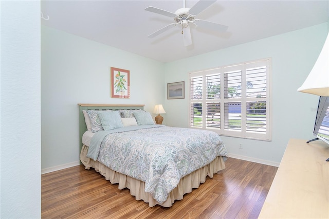 bedroom with light wood-style floors, ceiling fan, and baseboards