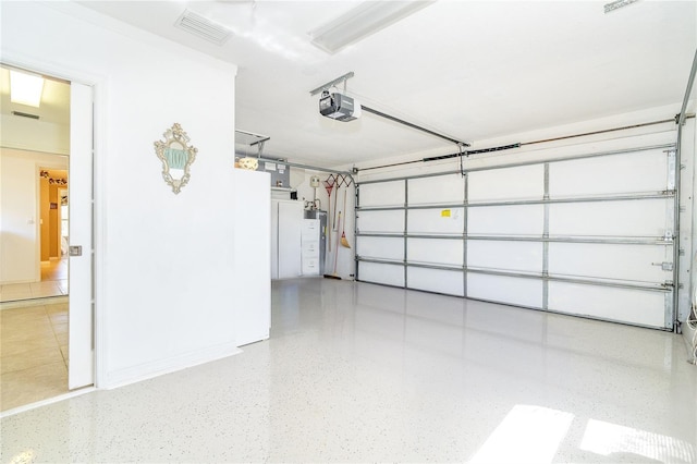 garage with a garage door opener, visible vents, and water heater