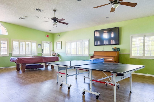 recreation room with ceiling fan, a textured ceiling, visible vents, and wood finished floors