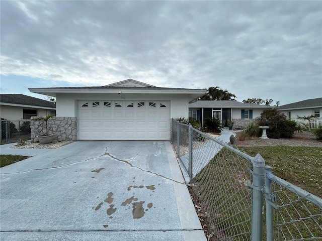 single story home with concrete driveway, an attached garage, fence, and stucco siding