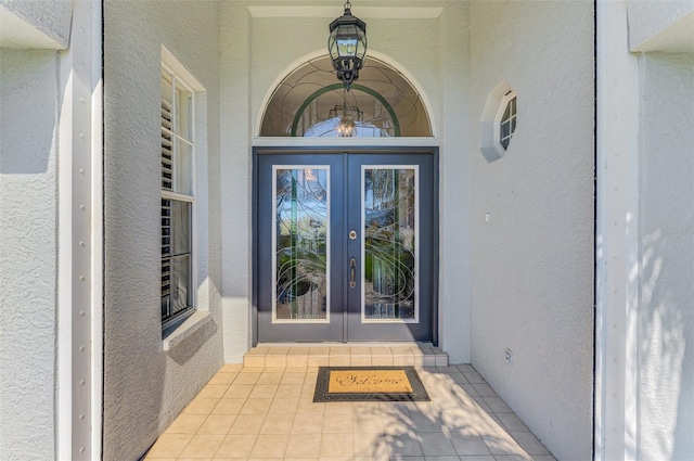 property entrance featuring french doors and stucco siding