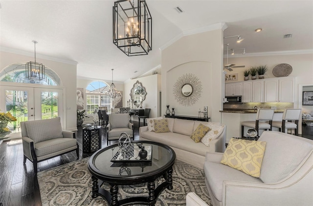 living room with a chandelier, ornamental molding, and hardwood / wood-style floors