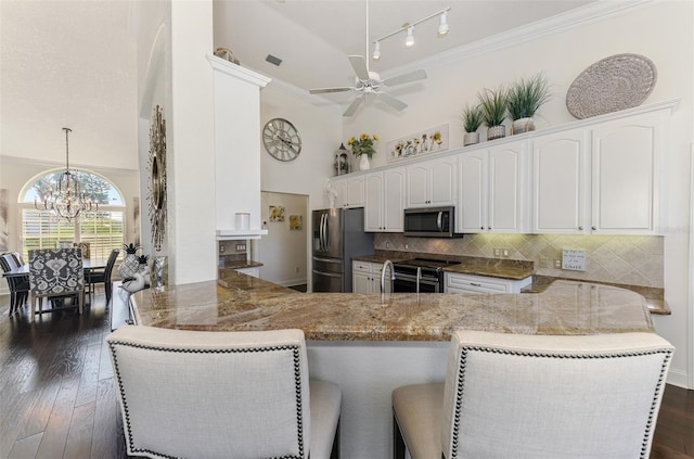 kitchen featuring stainless steel appliances, backsplash, ornamental molding, white cabinetry, and light stone countertops