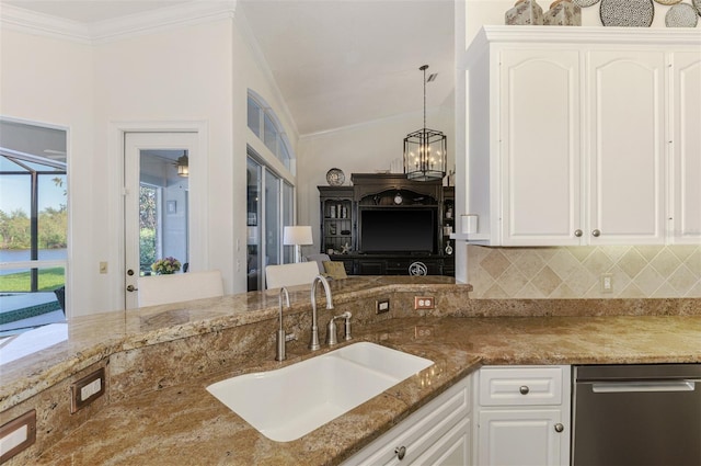 kitchen featuring light stone counters, crown molding, decorative backsplash, white cabinetry, and a sink