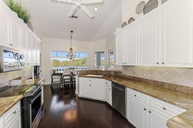 kitchen with white cabinets, a peninsula, stainless steel appliances, crown molding, and a sink