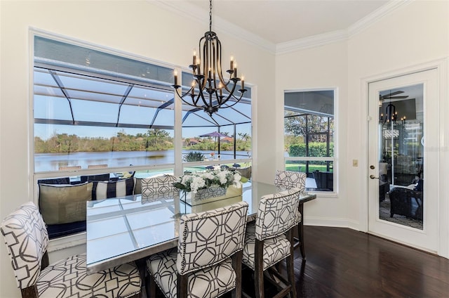 dining room featuring crown molding, a water view, an inviting chandelier, a sunroom, and wood finished floors