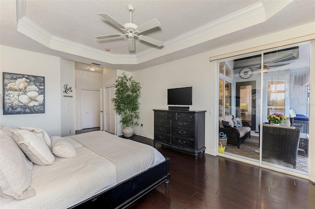 bedroom featuring a raised ceiling, hardwood / wood-style flooring, ornamental molding, a textured ceiling, and a closet