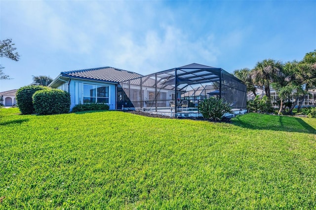 exterior space featuring a lanai, a tile roof, a yard, and stucco siding