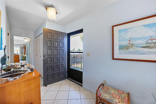 foyer featuring light tile patterned floors and a textured ceiling