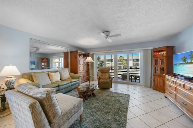 living area featuring light tile patterned floors, a textured ceiling, and a ceiling fan