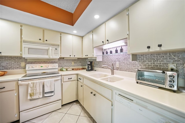 kitchen featuring a sink, cream cabinets, white appliances, light countertops, and light tile patterned floors