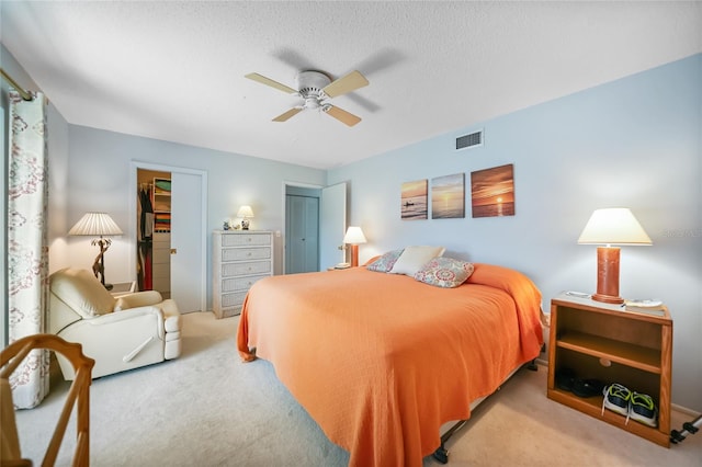 bedroom with visible vents, carpet flooring, a textured ceiling, and ceiling fan