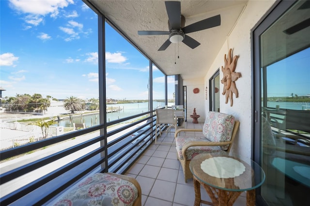 sunroom / solarium with a water view and ceiling fan