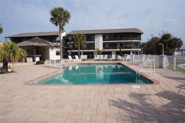 pool with a patio and fence