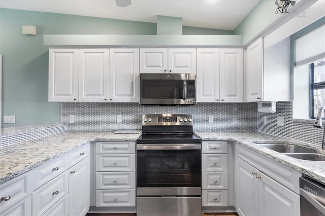 kitchen featuring a sink, tasteful backsplash, white cabinetry, and stainless steel appliances