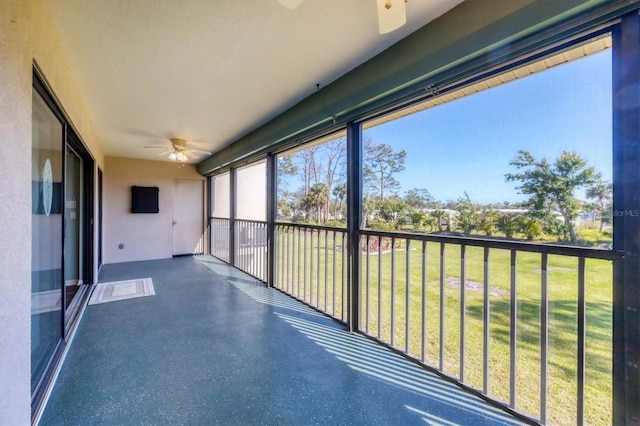 unfurnished sunroom featuring ceiling fan