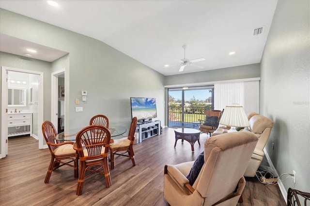 living room with visible vents, baseboards, lofted ceiling, and wood finished floors